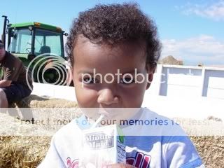 Photo of little boy enjoying his drink on the tractor trailer
